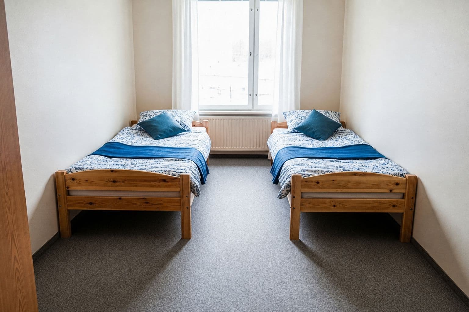 the bare ann arbor double before styling — two plain twin beds with basic bedding and empty walls